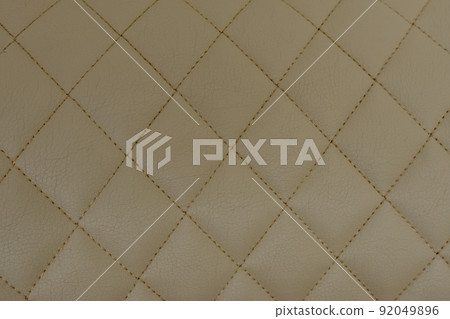 Background of beige leather quilted in the form of rhombuses 92049896
