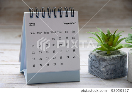 November 2023 white desk calendar on wooden table. Copy space 92050537