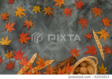 Frame concept made of fall maple leaves, walnuts on dark background. Autumnal season. Flat lay Frame concept made of fall maple leaves, walnuts on dark background. Autumnal season. Flat lay 92050923