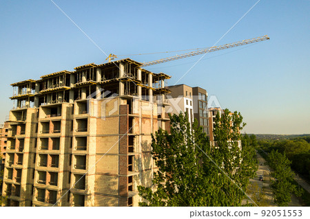 High multi storey residential apartment buildings under construction. Concrete and brick framing of high rise housing. Real estate development in urban area. High multi storey residential apartment buildings under construction. Concrete and brick framing of high rise housing. Real estate development in urban area. 92051553