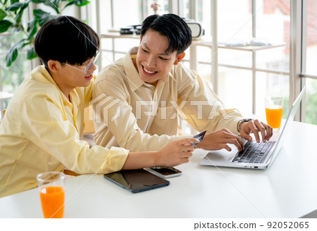 Couple gay or lgbt man enjoy to online shopping together using laptop and stay in living room Couple gay or lgbt man enjoy to online shopping together using laptop and stay in living room 92052065