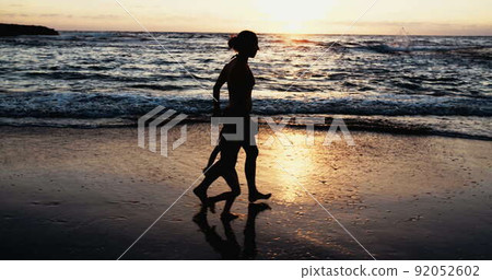 Slow motion of Mother and young girl running on the beach during sunset Slow motion of Mother and young girl running on the beach during sunset 92052602