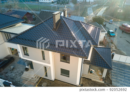 Aerial view of private house with ceramic shingles covered roof top. Investment in real estate concept 92052692