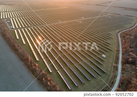 Aerial view of large sustainable electrical power plant with rows of solar photovoltaic panels for producing clean electric energy in evening. Concept of renewable electricity with zero emission 92052702