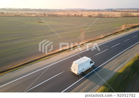 Aerial view of blurred fast moving cargo van driving on highway hauling goods. Delivery transportation and logistics concept 92052782