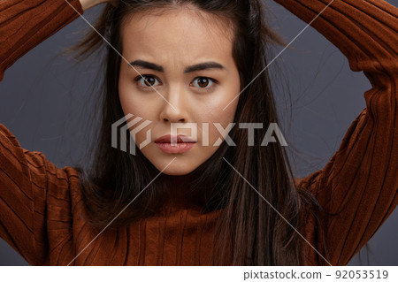 Brunette hand gestures brown sweater fashion Gray background Brunette hand gestures brown sweater fashion Gray background 92053519