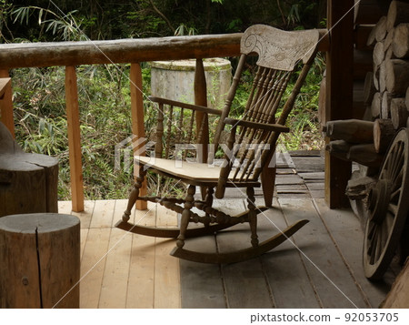 A retro landscape with rocking chairs on a sunny wooden deck 92053705