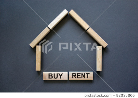Model of a wooden house from wooden blocks. Words 'buy rent'. Copy space. Business concept. Beautiful grey background. 92053806