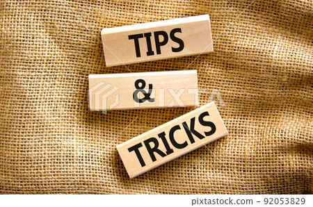 Tips and tricks symbol. Concept words Tips and tricks on wooden blocks. Beautiful canvas table, canvas background. Business, tips and tricks concept. Copy space. 92053829