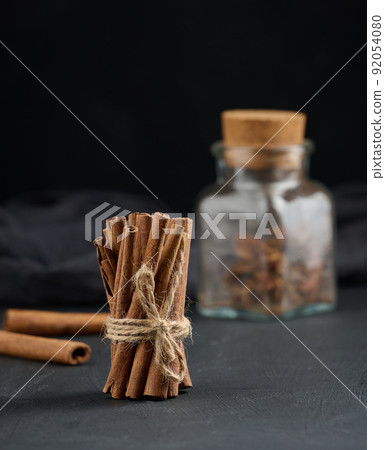 Bunch of dry cinnamon on black table, spice Bunch of dry cinnamon on black table, spice 92054080
