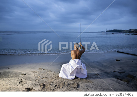 Male senior Japanese kendo wielding a bamboo sword Male senior Japanese kendo wielding a bamboo sword 92054402