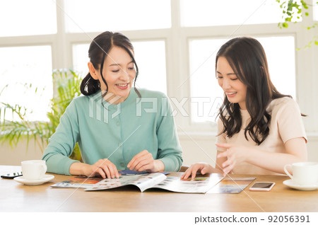 Parents and children working on travel francs while looking at the pamphlet Parents and children working on travel francs while looking at the pamphlet 92056391