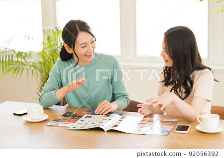 Parents and children working on travel francs while looking at the pamphlet Parents and children working on travel francs while looking at the pamphlet 92056392