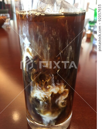 一杯與牛奶混合的冷冰咖啡 一杯與牛奶混合的冷冰咖啡 92057655