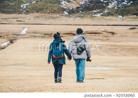 Back view of lovely couple holding each other hands, travelling in Iceland. Back view of lovely couple holding each other hands, travelling in Iceland. 92058060