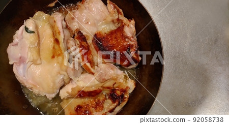 Chicken thighs being baked in an iron skillet 92058738