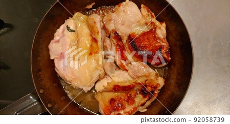 Chicken thighs being baked in an iron skillet Chicken thighs being baked in an iron skillet 92058739