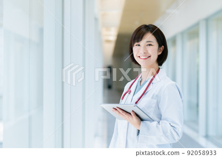 Female doctor walking in the corridor 92058933