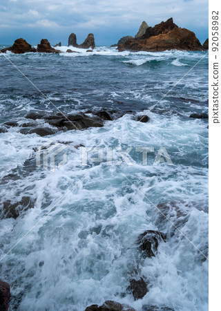 The Sea of Japan in winter, dotted with rocky reefs flooded with rough waves 92058982