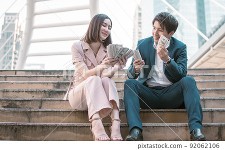 Business man and woman are very happy with a lot of money 92062106