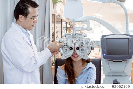 Ophthalmologist doing eyesight test to a woman 92062109