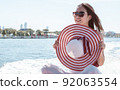 Beautiful woman traveling by boat with background of cityscape 92063554