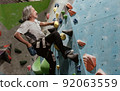 Old man climbing rock mountain 92063559