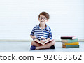 A boy reading books at home 92063562