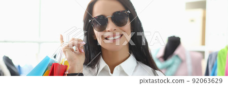 Young woman shopaholic smiling and carry packages with clothes 92063629