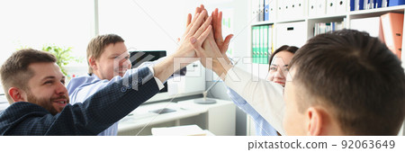 Witty colleagues performing high five gesture in order to celebrate important profitable project 92063649