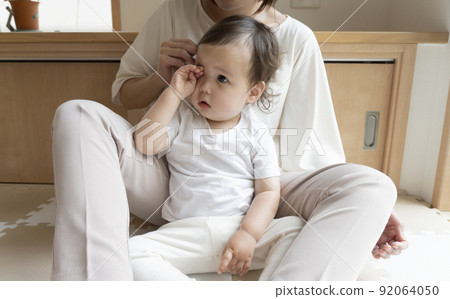 Half-child who is hugged by his mother and rubs his eyes Half-child who is hugged by his mother and rubs his eyes 92064050