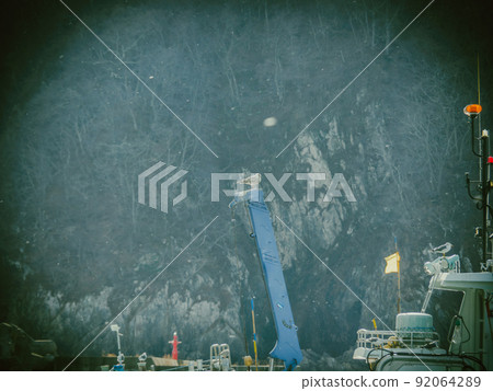 A fishing port with flickering snow and a fishing boat with a crane A fishing port with flickering snow and a fishing boat with a crane 92064289