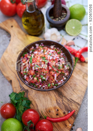 freshly made salsa dip sauce - chopped garlic, tomatoes and onion in wooden bowl freshly made salsa dip sauce - chopped garlic, tomatoes and onion in wooden bowl 92065098