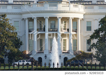 望向華盛頓白宮的正面（南側）。一座有白色柱廊和在早晨陽光下閃耀的噴泉的建築。 92065810