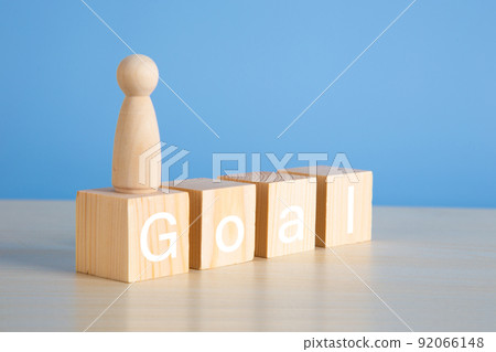Wooden people figures on top of wooden blocks. Goal achievement. 92066148