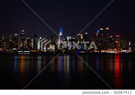 New York Manhattan seen from Weehawken. Illuminated buildings and a cruise ship on the Hudson River. New York Manhattan seen from Weehawken. Illuminated buildings and a cruise ship on the Hudson River. 92067411