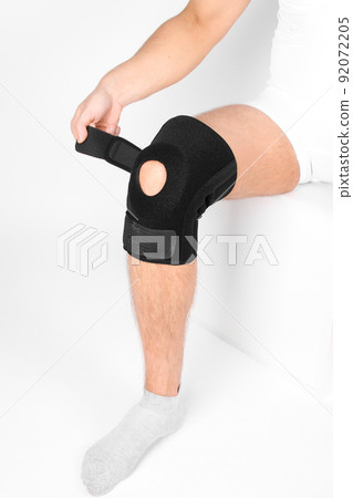 Knee Support Brace on leg isolated on white background. Elastic orthopedic orthosis. Anatomic braces for knee fixation, injuries and pain. Protective knee joint bandage sleeve. Trauma, rehabilitation. Knee Support Brace on leg isolated on white background. Elastic orthopedic orthosis. Anatomic braces for knee fixation, injuries and pain. Protective knee joint bandage sleeve. Trauma, rehabilitation. 92072205