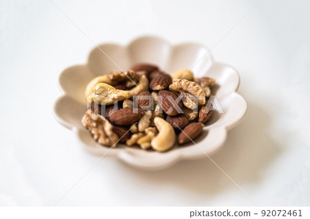 Assort nuts such as almonds and walnuts on a plate. Antioxidant effect of vitamin E 92072461