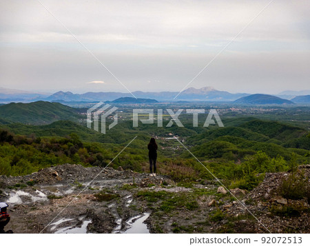 Standing girl with hills and mountain panorama Standing girl with hills and mountain panorama 92072513