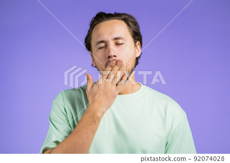Tired sleepy man yawns. Lazy guy showing emotion of very boring, uninteresting,. Violet studio 92074028