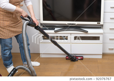 [Middle housewife cleaning flooring with a cyclone cleaner] 92076767