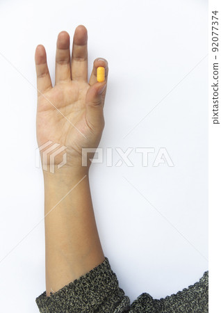Female hand picking one pill isolated on white background with customizable space for text or ideas. Female hand picking one pill isolated on white background with customizable space for text or ideas. 92077374