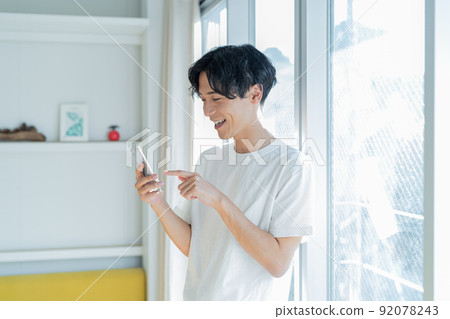 操作智能手機的一個年輕人 92078243