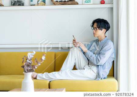 操作智能手機的一個年輕人 92078324
