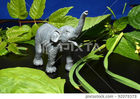 Children's toy, an African elephant with a raised trunk against the sky. Children's toy, an African elephant with a raised trunk against the sky. 92078378