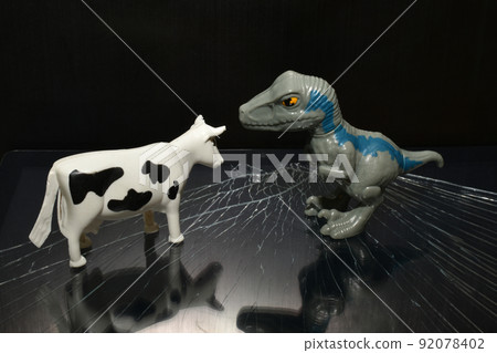 Children's toys cow and dinosaur on dark. Children's toys cow and dinosaur on dark. 92078402