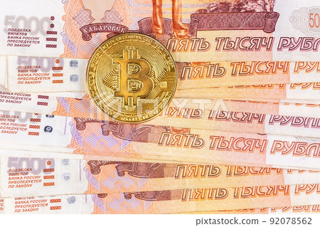 Bitcoin coins on Russian banknotes. 92078562