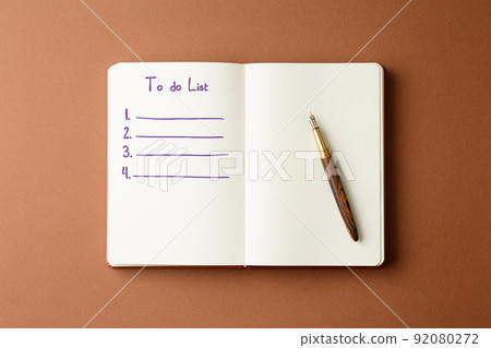 Open diary with fountain pen and potted plant. 92080272