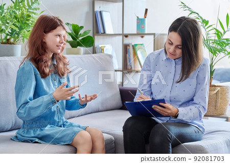 Female professional child psychologist working with preteen girl in office Female professional child psychologist working with preteen girl in office 92081703