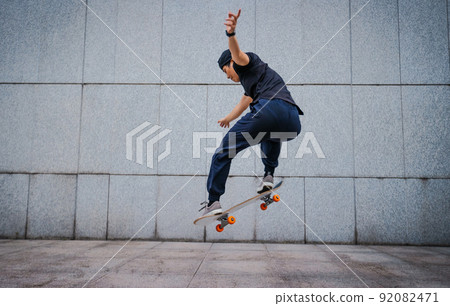 Asian woman skateboarder skateboarding in modern city Asian woman skateboarder skateboarding in modern city 92082471